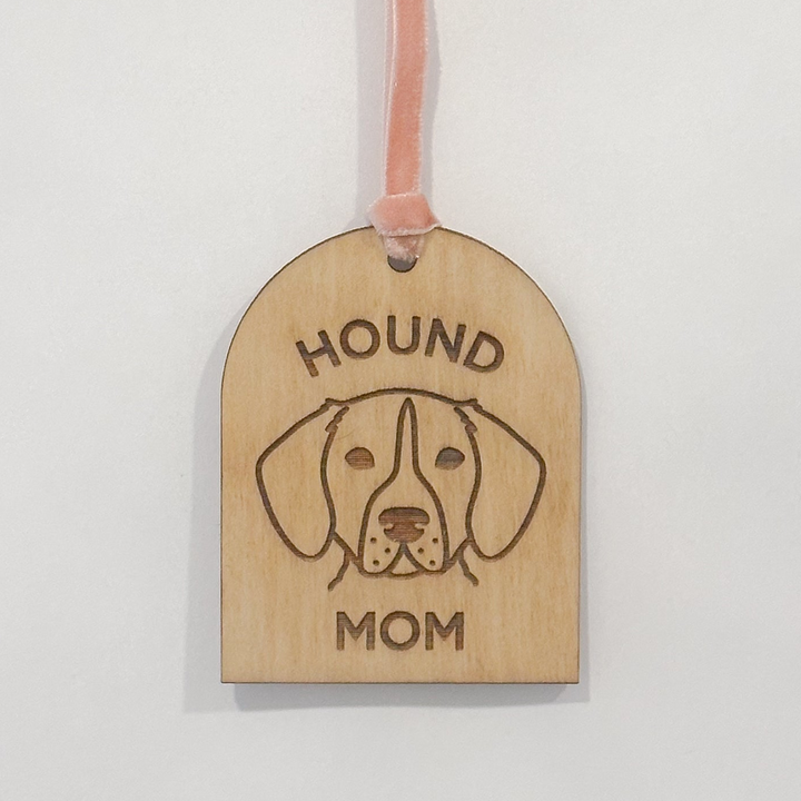 A wooden hound-shaped ornament engraved with &