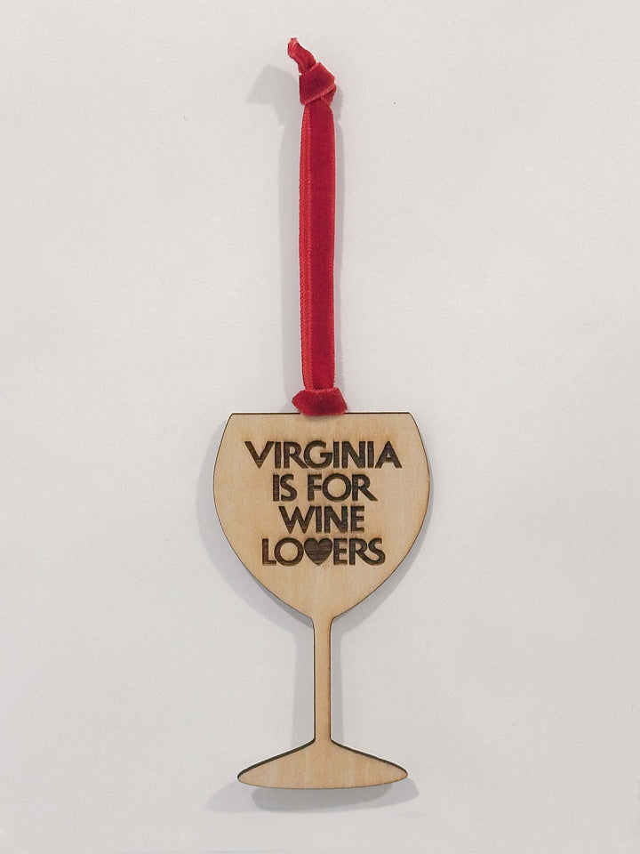 A wooden wine glass shaped ornament with the text &